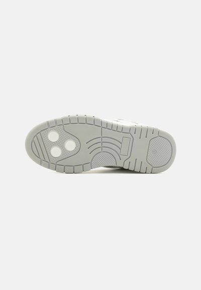 Gray sneaker outsole featuring a textured tread pattern, three circular indentations, and curved lines for added grip and flexibility.