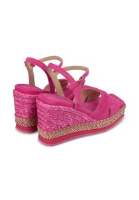 Sandales à talons en daim rose avec des brides entrecroisées et une ouverture à l'avant. Détail de semelle intermédiaire en jute tissé et semelle en caoutchouc pour une meilleure adhérence.