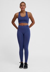 Dunkelblauer Sport-BH und hochtaillierte Leggings aus dehnbarem Material, mit einer figurschmeichelnden Passform und Logodetails am Bund.
