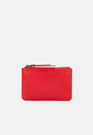Pochette en cuir rouge avec fermeture éclair, logo "Liebeskind Berlin" discrètement embossé, forme rectangulaire et deux glissières en haut.