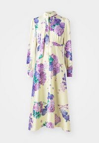 Langsleeve jurk in soepele stof, met een gele basis en paarse bloemenpatronen. Bevat een strikhalslijn en een geplooide taille.