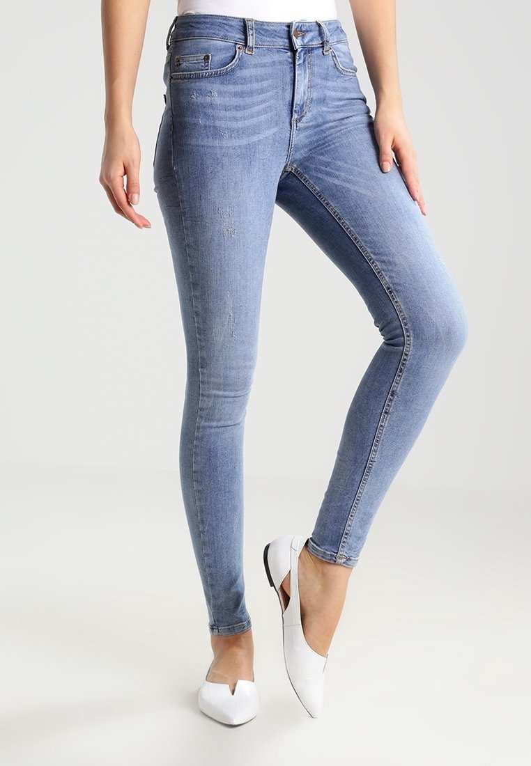 Ljusblå skinny jeans i denim med en blekt design, lätt slitning och hög midja. Matchas med vita ballerinas.