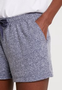 Gray cotton blend shorts with an elastic waistband and drawstring. Features side pockets and a soft, textured finish.