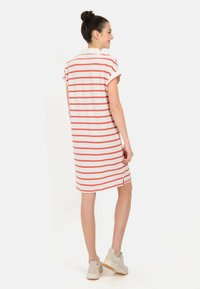 Gestreiftes Kleid mit kurzen Ärmeln, aus leichtem Stoff; verfügt über weiße und korallenfarbene Streifen, seitliche Schlitze und eine lockere Passform.