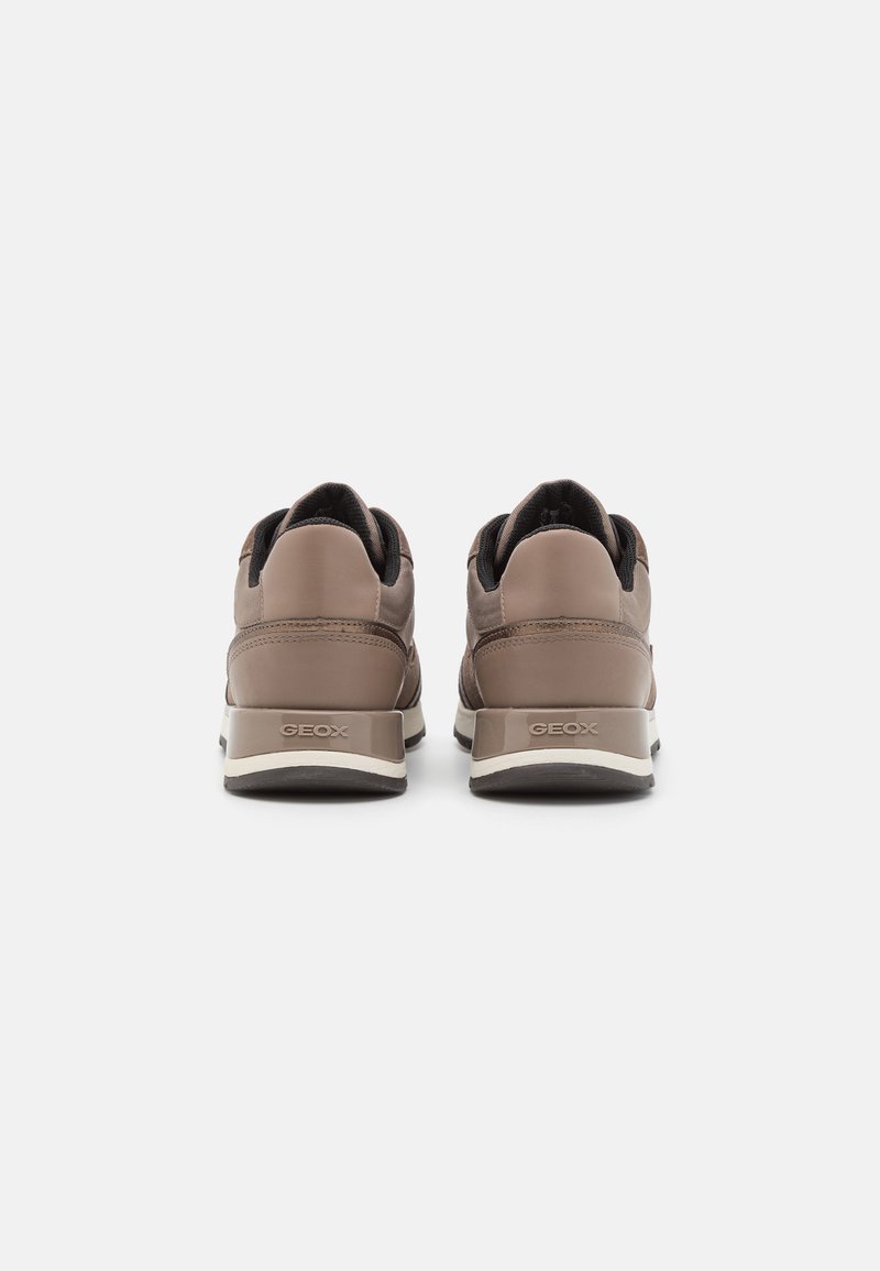 Braune Leder-Sneaker mit gepolstertem Absatz, schwarzen Akzenten und einer strukturierten Gummisohle. Die Geox-Branding ist an der Seite sichtbar.