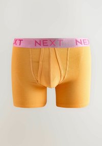 Sárga boxer alsónadrág rózsaszín derékkal, amelyen a "NEXT" szó vastag betűkkel szerepel. Simító anyag, testhezálló dizájn és elülső zseb.