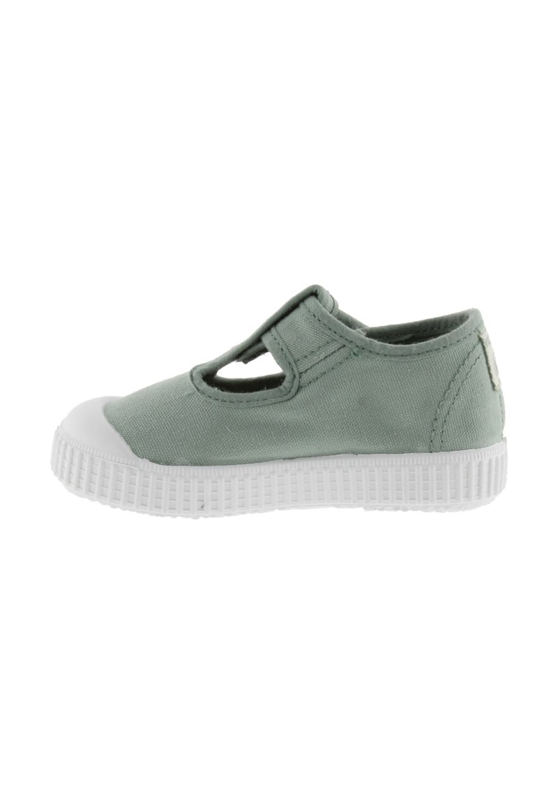 Scarpe in tela verde con punta e suola in gomma bianca, presentano un design con ritagli sulla parte superiore e una dettagliatura cucita lungo le cuciture.