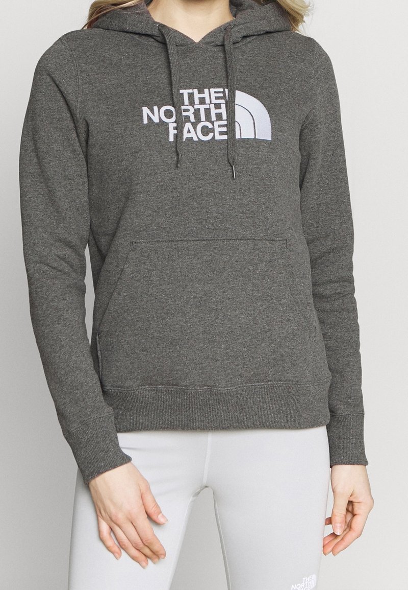 Felpa grigia con cappuccio, tasca a marsupio, e logo "THE NORTH FACE" bianco sul petto. Tessuto morbido, polsini a costine.