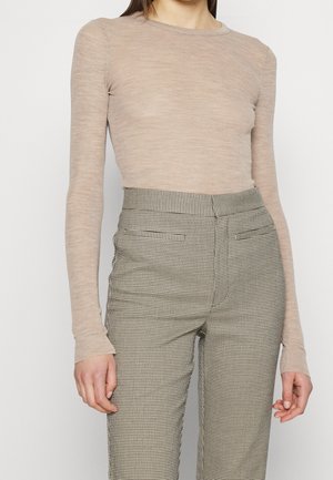 Beige langærmet top lavet af letvægtsstof, kombineret med højttaljede ternede bukser med en slank pasform og sidelommer.