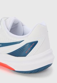 White athletic shoe with a textured upper, blue accent panels, and a red "SKY ELITE FF" label. Rubber sole with tread patterns visible.