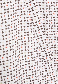 Textil mit weißem Hintergrund und einem geometrischen Muster aus unregelmäßigen braunen, beigen und orangefarbenen Formen. Weiches und leichtes Material.