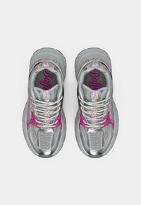 Adidași sport argintii cu accente roz, parte superioară din plasă și detalii reflectorizante. Au guler căptușit și tălpi texturate pentru aderență.