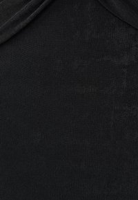 Melnas ribota auduma ar gludu tekstūru, ar drapētu dizainu augšpusē un vienmērīgu, smalku spīdumu visā virsmā.