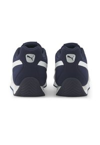 Marinblå sportskor med vita accenter, ovandel i mesh, vadderad krage och texturerade gummisulor som visar ett zigzag-mönster.