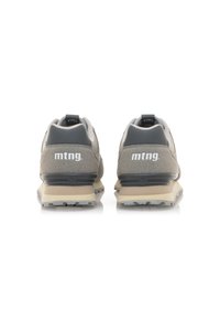Zapatillas grises que presentan una mezcla de texturas, incluyendo materiales lisos y de ante, con una suela acolchada y un detalle del logo en el talón.