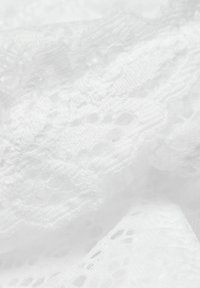 Witte kantstof met ingewikkelde patronen en openwerk elementen. Zachte textuur en delicate ontwerp met gevarieerde, herhalende motieven.