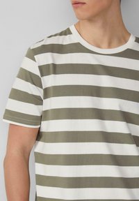 Katoenen T-shirt met horizontale olijfgroene en witte strepen, ronde hals, korte mouwen, zachte textuur en contrasterende stiksels.