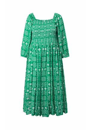 Robe midi verte avec motifs géométriques et floraux blancs, corsage smocké, encolure carrée et longues manches bouffantes avec poignets élastiques.