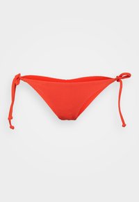 Červené bikiny s vrúbkovaním na spodnej časti s viazaním na každej strane, majúce trojuholníkový tvar a jemnú textúru.