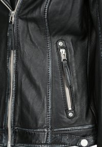 Schwarze Lederjacke mit einer Reißverschlusstasche, silbernem Zubehör, sichtbaren Nähten und einer glatten Textur. Reißverschluss-Ziehband an der Hauptöffnung.