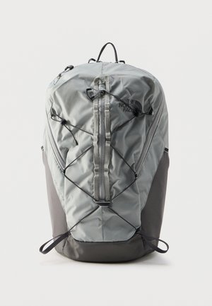 Light gray and dark gray North Face backpack with front elastic cord, top handle, and vertical zipper on a white background.