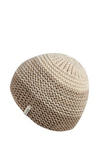 Knit beanie in cream and light brown, featuring a circular top, textured design, and a small branded tag on the side.
