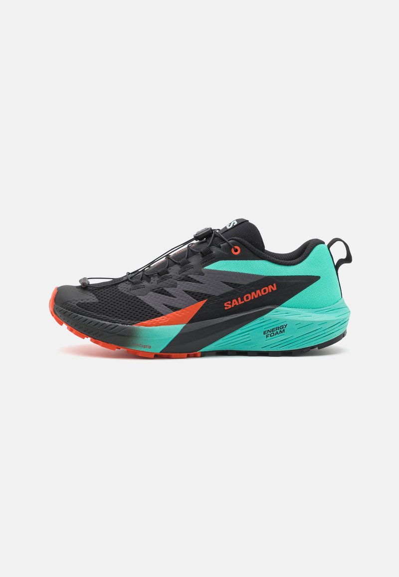 Scarpa da corsa nera e teal con accenti arancioni, tomaia in rete, forma aerodinamica e suola texture. Presenta un sistema di lacci rapidi e una presa robusta.