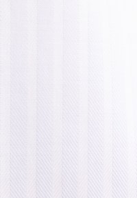 Tissu blanc avec des rayures verticales texturées alternées présentant des motifs subtils en chevrons et côtelés.
