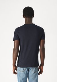 T-shirt in cotone blu navy con maniche corte e scollatura rotonda, texture liscia, dettagli di cucitura visibili sul retro.