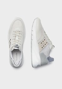 Jasnoszare buty sportowe z siateczkową cholewką i zamszowymi akcentami, z wyściełaną podeszwą i dekoracyjnymi ćwiekami na boku.