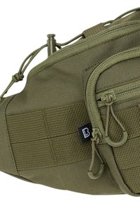 Borsa in nylon verde a vita con diversi scomparti con zip, superficie testurizzata, corde regolabili e etichetta di branding nera. Punti di attacco modulari.