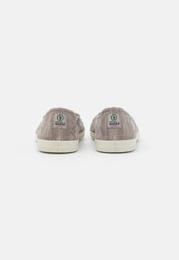 Szürke vászon slip-on cipők fehér gumitalppal. Zöld logó címke található a sarkán, texturált anyaguk pedig légáteresztő.