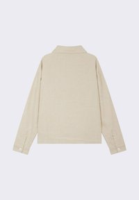 Camicia beige a maniche lunghe realizzata in tessuto texturizzato con sottili motivi astratti bianchi e colletto pieghevole con polsini a bottoni.