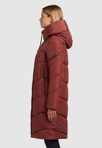 Cappotto imbottito rosso con cappuccio, caratterizzato da un design trapuntato diagonale, tasche con cerniera e un logo sull'orlo.