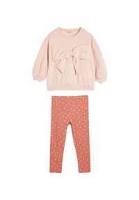 Sudadera rosa con un gran lazo en la parte delantera, combinada con leggings rosa que presentan pequeños patrones de corazones blancos. Tejido suave, diseño casual.