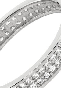 Bague en argent à double anneau, l'un orné de petites pierres claires rondes alignées, l'autre présentant une surface texturée.