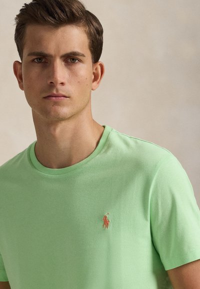 Ανοιχτό πράσινο βαμβακερό μπλουζάκι με στρογγυλή λαιμόκοψη και μικρό κεντημένο λογότυπο στο αριστερό στήθος. Λείο υφή και άνετη, καθημερινή εφαρμογή.