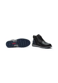 Botas negras de cuero hasta el tobillo con un acabado suave, que presentan una puntera redonda, cordones en la parte delantera, una cremallera lateral y una suela de goma texturizada en color azul marino.