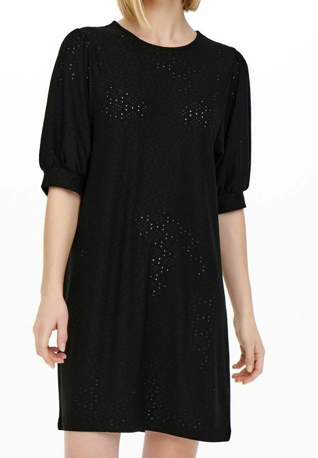 Robe noire à manches courtes bouffantes, présentant un motif subtil en broderie anglaise, portée par une femme à la peau claire et aux cheveux blonds.