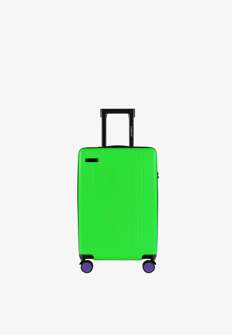 Groene harde koffer met verticale groeven, zwart intrekbaar handvat en paarse wielen. Compact ontwerp, geschikt voor reizen.