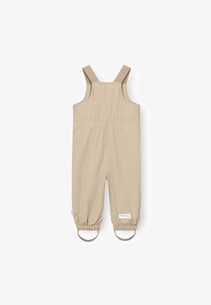 Beige vanntette barneoveraller med justerbare skulderstropper og elastiske mansjetter med fotstropper.