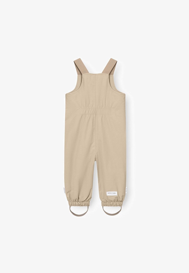 Μπεζ αδιάβροχες ολόσωμες φόρμες για παιδιά με ρυθμιζόμενους ιμάντες στους ώμους και ελαστικές μανσέτες με ιμάντες ποδιών.