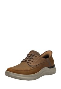 Zapato de cuero marrón con cordones, punta redondeada, suela de goma gris gruesa y acentos texturizados en la parte superior y la lengüeta. Adecuado para uso casual.