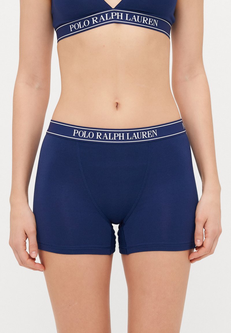 Mornarško modri bokserki z rebrasto teksturo, elastičen pas z belim napisom "POLO RALPH LAUREN", dolžina do sredine stegna, prilegajoča zasnova.