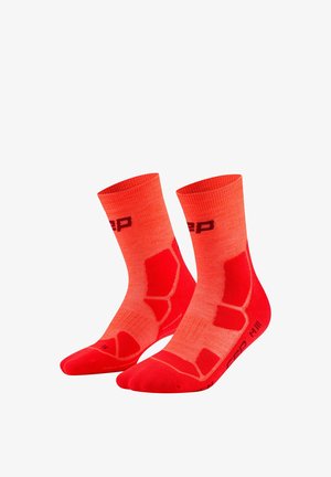 Pair of bright red athletic socks with darker red padded areas and black logo text on ankle and foot.