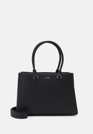 Sac tote en cuir noir avec double anse supérieure, surface texturée et accents en métal doré. Doublure de l'épaule ajustable incluse.