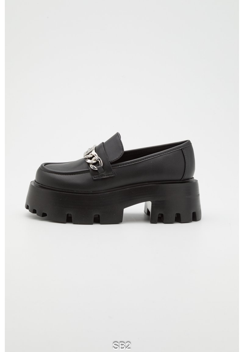 Mocassins noirs à plateforme avec une semelle épaisse, dotés d'un dessus en cuir lisse et d'une chaîne décorative en argent à l'avant.