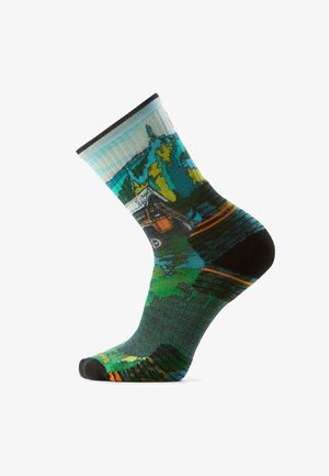Sock featuring a colorful outdoor scene with mountains, trees, a cabin, and a parked car in green, blue, and orange tones.