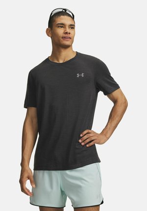 Black short-sleeve t-shirt made of a textured fabric, featuring a small grey logo on the chest. Worn with light blue athletic shorts.