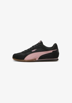 Baskets Puma noires avec bande latérale rose, semelle en gomme et lacets noirs vues de côté sur un fond blanc.